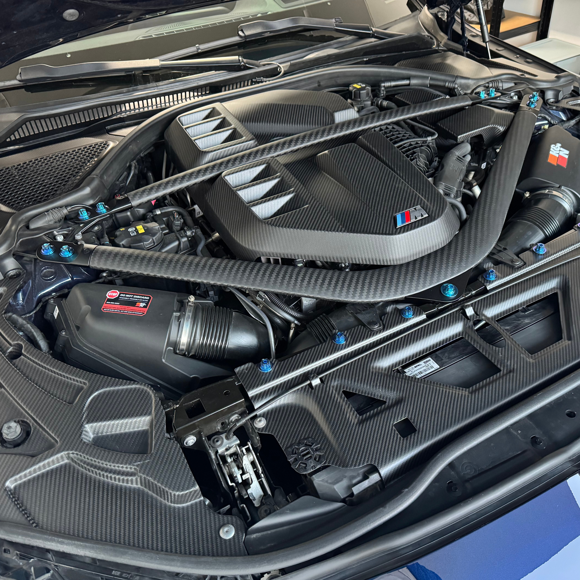 Car engine bay with visible branding on a blue background