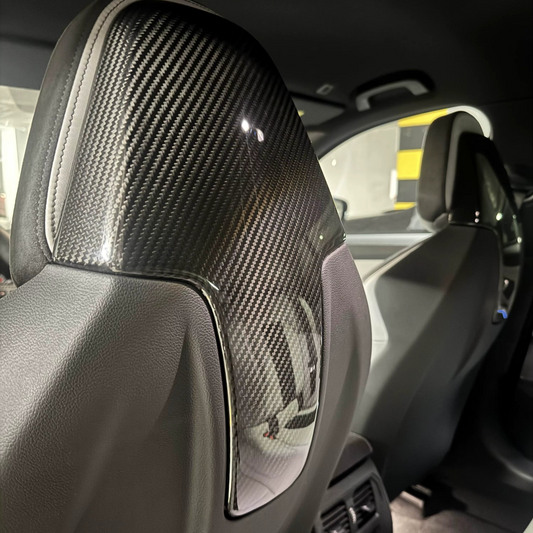 Car interior with a carbon fiber headrest cover.